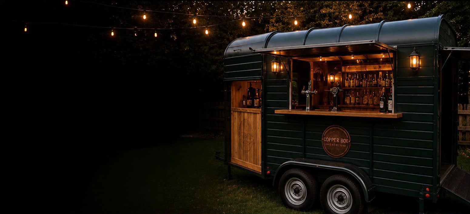 The Copper Box Events converted horsebox bar lit up at an evening event